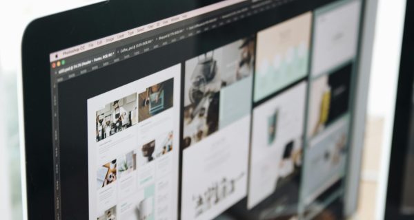 A modern computer screen displaying web design work, showcasing creative visuals in a workspace.